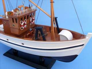 This wooden fishing boat model is attached to a sturdy wooden base