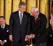 Palmer gives President Bush golf tips before being awarded the 