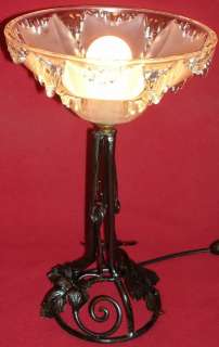 An opalescent molded Thick glass for shade on a fine wrought iron base 